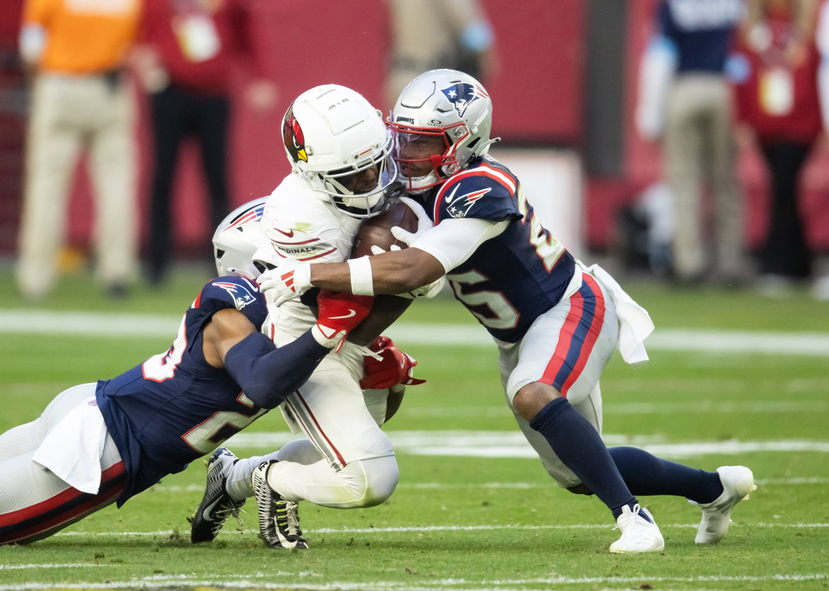 Dec 15, 2024; Glendale, Arizona, USA; New England Patriots cornerback Marcus Jones (25) tackles Arizona Cardinals wide receiver Greg Dortch (4) at State Farm Stadium.