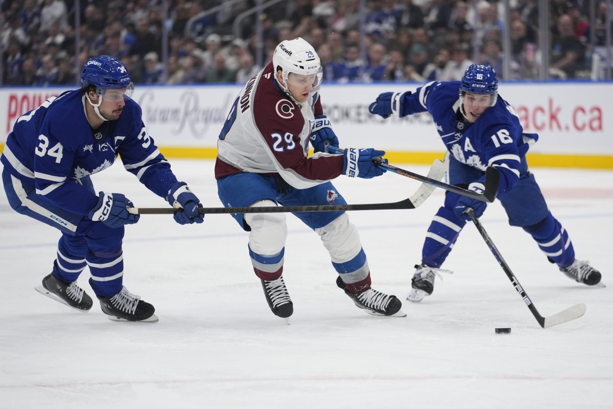 Colorado Avalanche forward Nathan MacKinnon (29) tries to get past Toronto Maple Leafs forward Auston Matthews (34) and forward Mitch Marner (16) during the second period at Scotiabank Arena. 