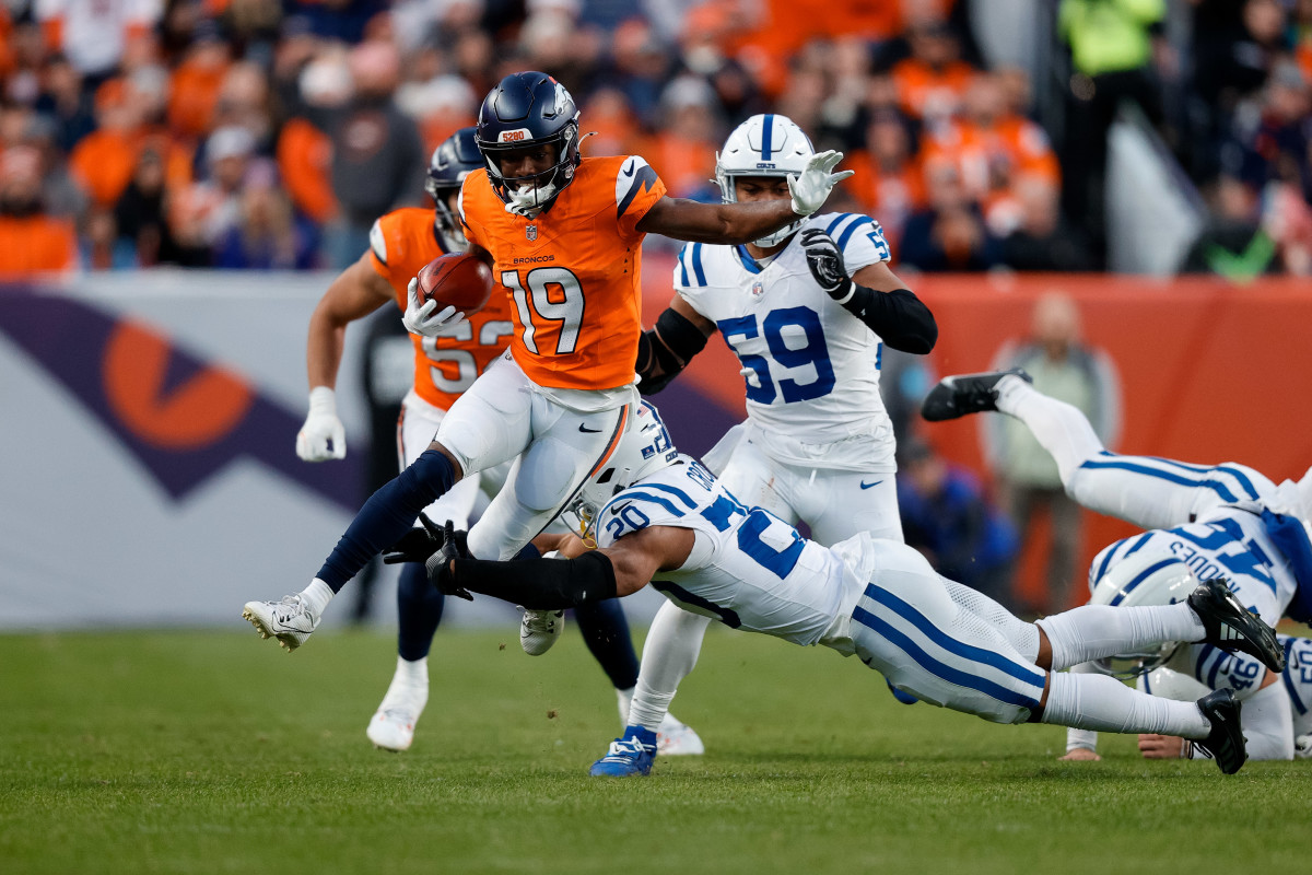 Denver Broncos wide receiver Marvin Mims Jr. (19) runs through the tackle of Indianapolis Colts safety Nick Cross (20) in the third quarter at Empower Field at Mile High.