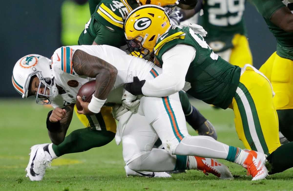 Miami Dolphins QB Tua Tagovailoa (1) is sacked by Green Bay Packers DE Lukas Van Ness (90)