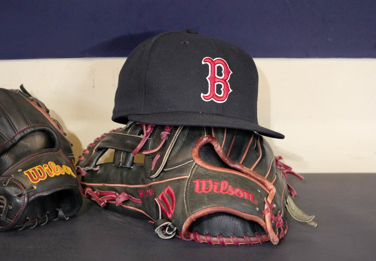 A Boston Red Sox hat and glove sit in the dug out before a game against the Milwaukee Brewers at American Family Field.