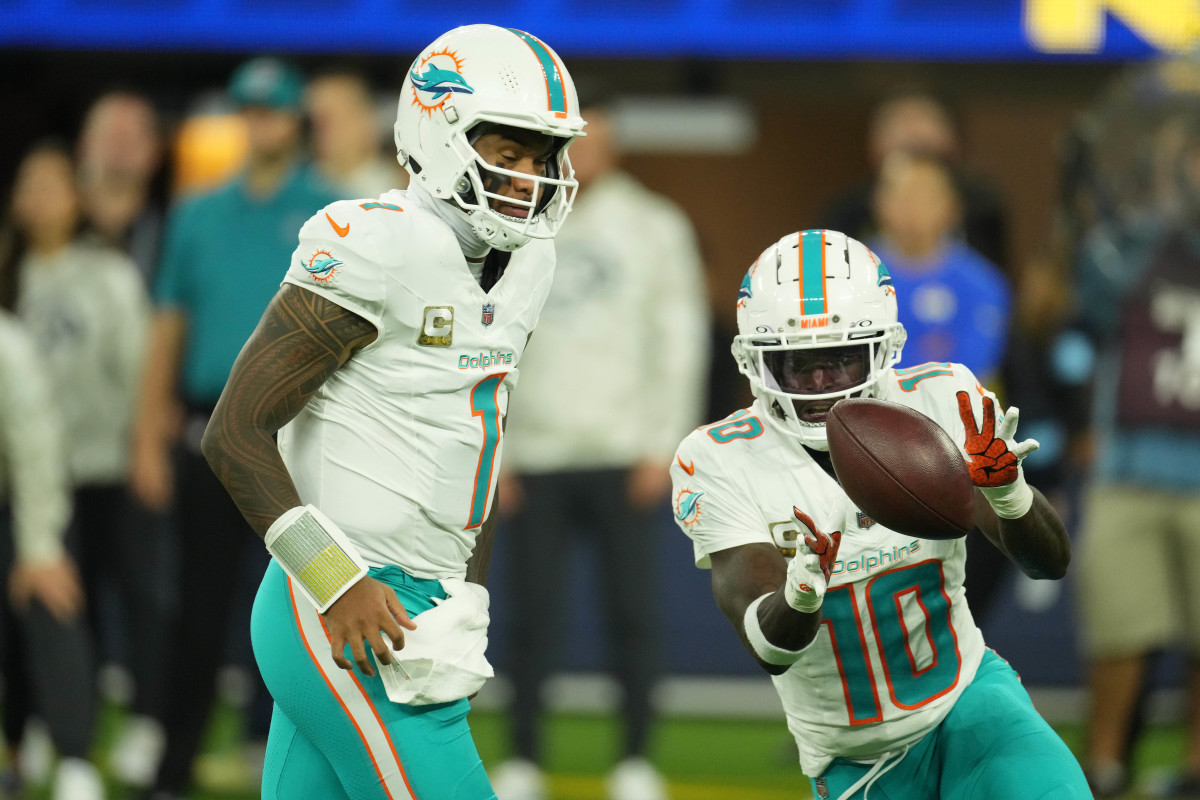Miami Dolphins quarterback quarterback Tua Tagovailoa (1) pitches the ball to wide receiver Tyreek Hill (10) against the Los Angeles Rams in the second half at SoFi Stadium.