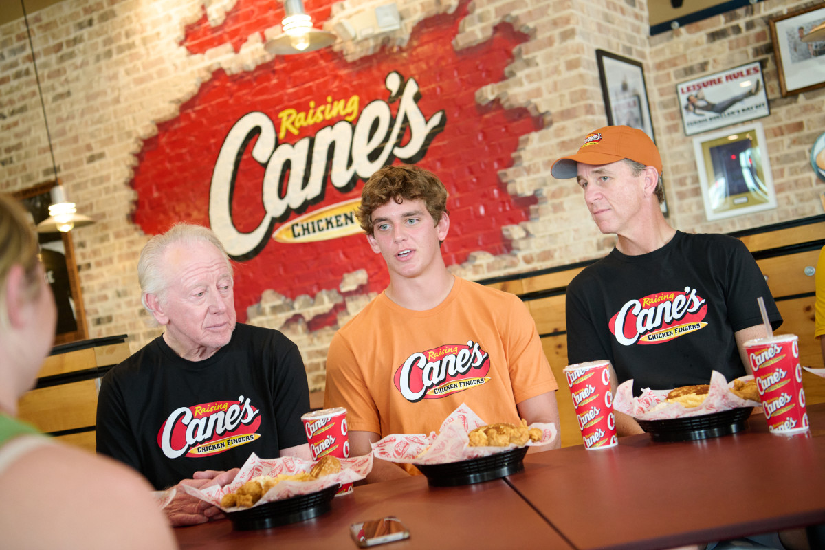 Longhorns quarterback Arch Manning (center), with Archie Manning (left) and Cooper Manning (right).