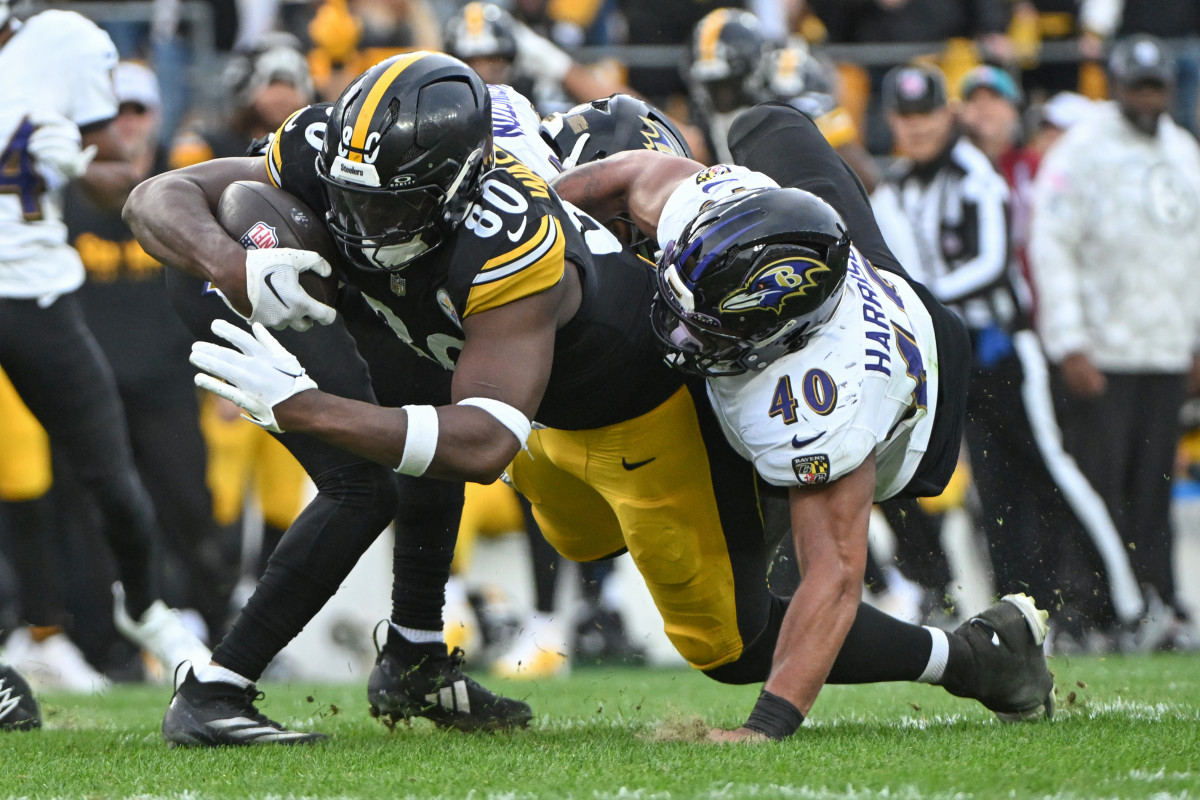 Pittsburgh Steelers tight end Darnell Washington (80) dives for extra yardage while being tackled by Baltimore Ravens linebacker Malik Harrison (40).