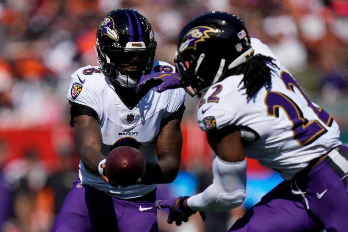 Lamar Jackson handing the ball off to running back Derrick Henry.