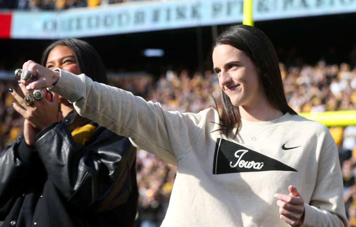 Former Iowa star Caitlin Clark shows off her rings at Kinnick Stadium