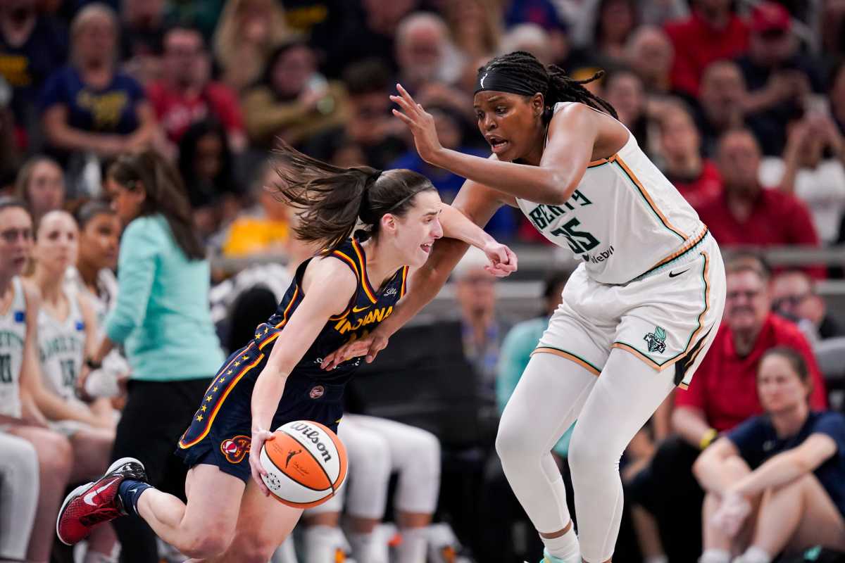 Indiana Fever guard Caitlin Clark drives past New York Liberty center Jonquel Jones.