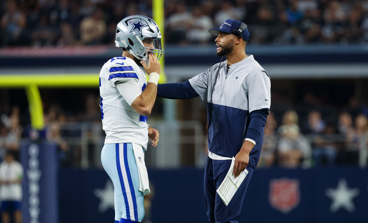 Dallas Cowboys quarterback Dak Prescott (right) speaks with Dallas Cowboys quarterback Will Grier (15)