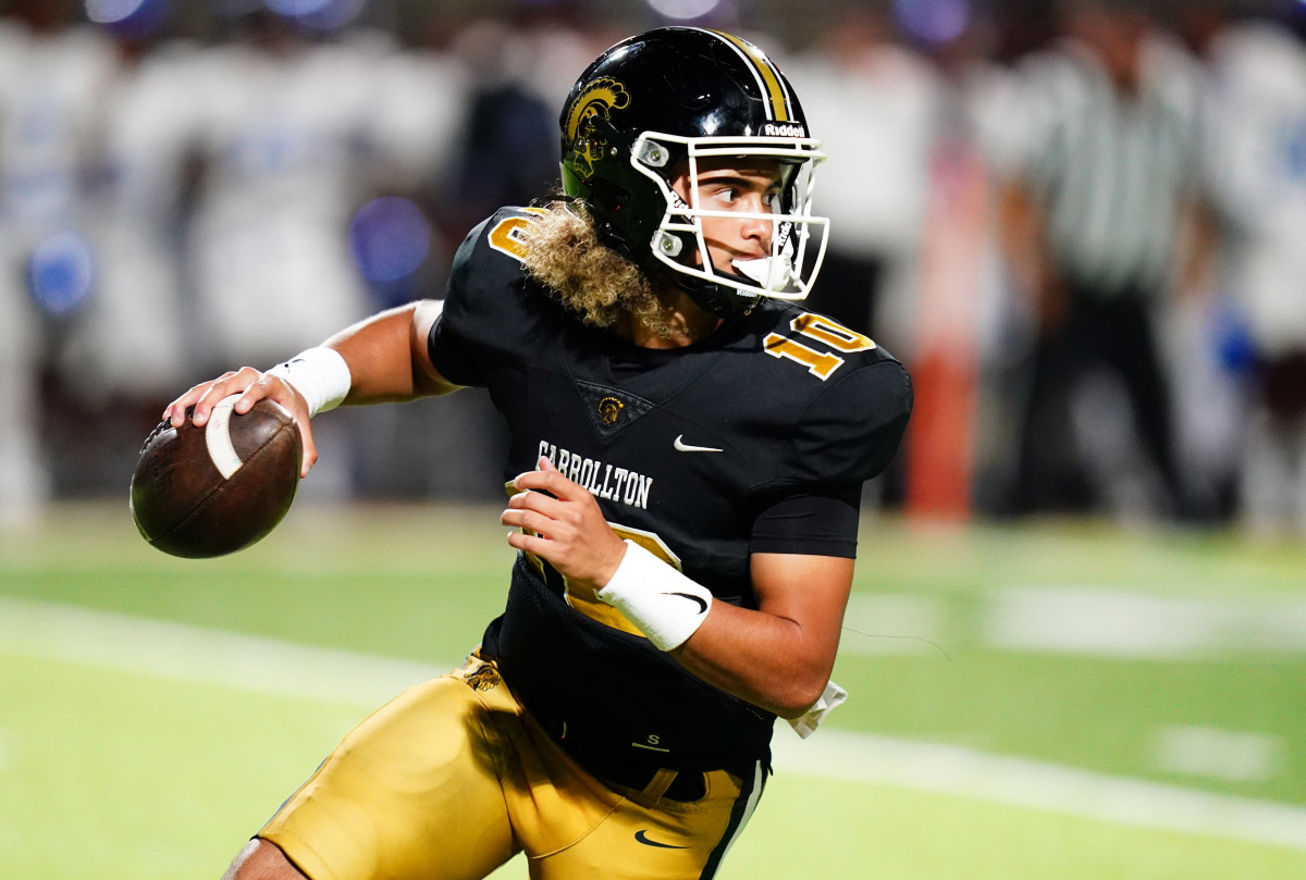 Carrollton Trojans quarterback Julian Lewis (10) scrambles out of the pocket against the Westlake Lions during the first half at Grisham Stadium. The 17-year-old Carrollton High student has already committed to playing for the University of Southern California Trojans and has been considered one of the top high school quarterback prospects.