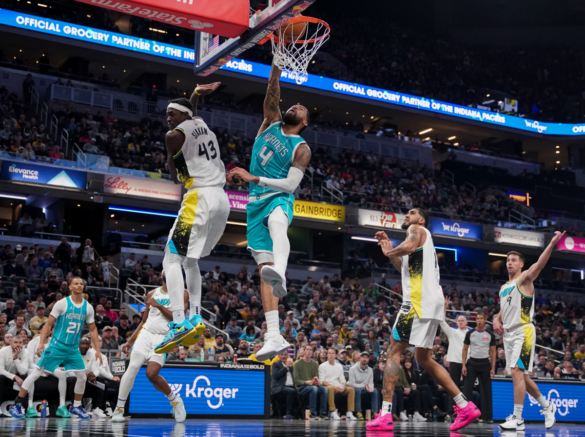 Dec 8, 2024; Indianapolis, Indiana, USA; Charlotte Hornets center Nick Richards (4) dunks the ball past Indiana Pacers forward Pascal Siakam (43) during the second half at Gainbridge Fieldhouse. Mandatory Credit: Robert Goddin-Imagn Images