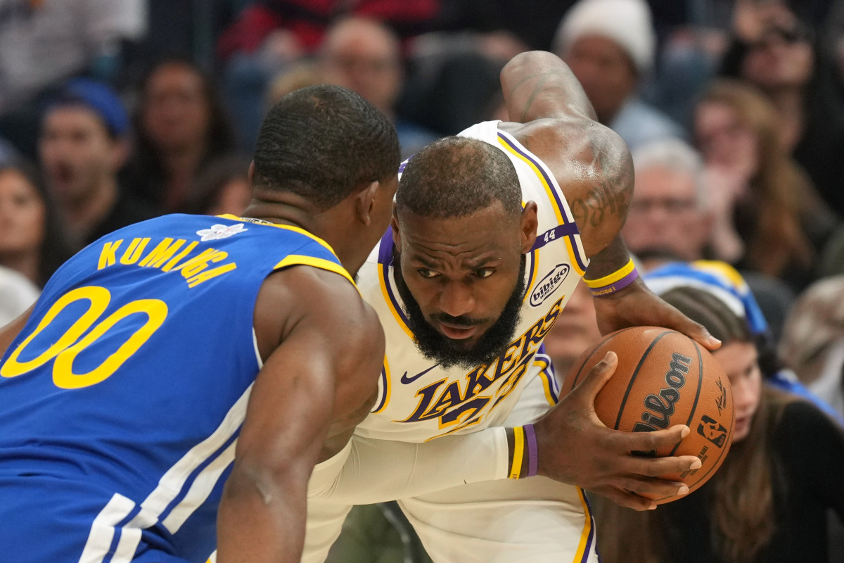 Dec 25, 2024; San Francisco, California, USA; Los Angeles Lakers forward LeBron James (right) handles the ball against Golden State Warriors forward Jonathan Kuminga (00) during the second quarter at Chase Center