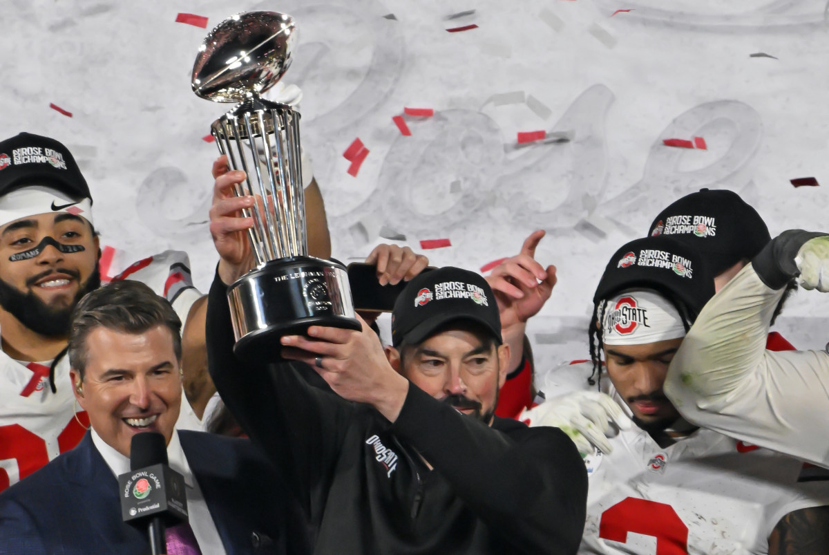 Ohio State Buckeyes head coach Ryan Day holds up the Rose Bowl championship trophy after defeating the Oregon Ducks.