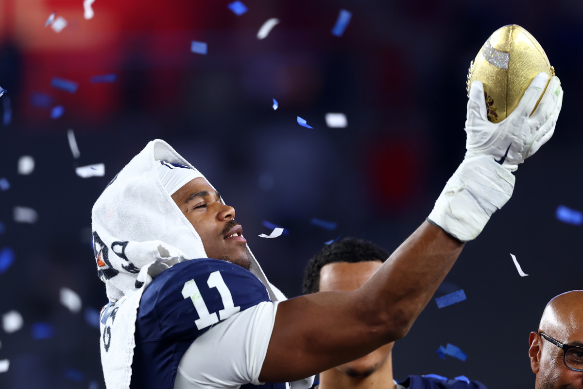 Dec 31, 2024; Glendale, AZ, USA; Penn State Nittany Lions defensive end Abdul Carter (11) reacts with the trophy after the game against the Boise State Broncos in the Fiesta Bowl at State Farm Stadium. Mandatory Credit: Mark J. Rebilas-Imagn Images  