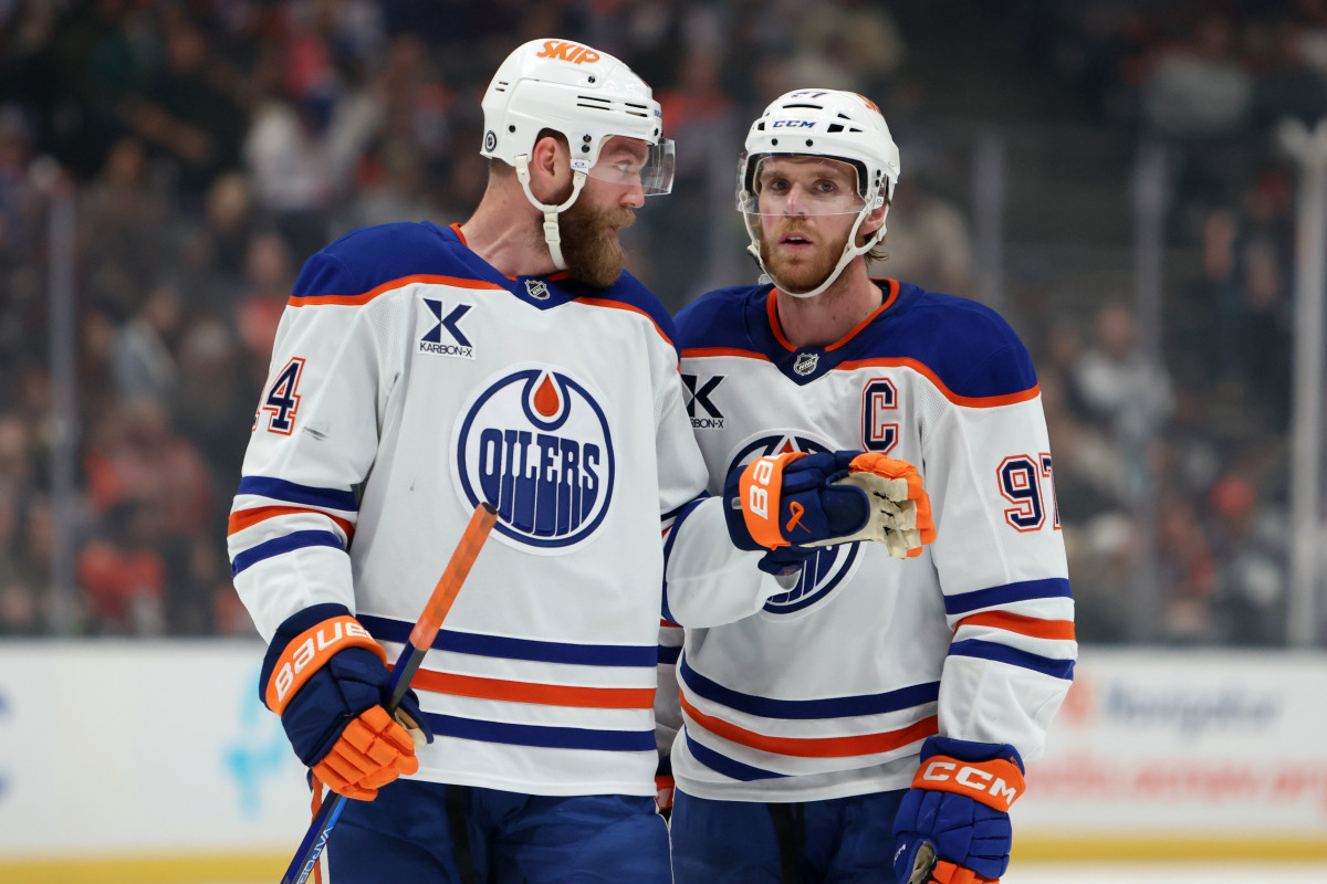 Edmonton Oilers center Connor McDavid (97) talks to defenseman Mattias Ekholm (14).