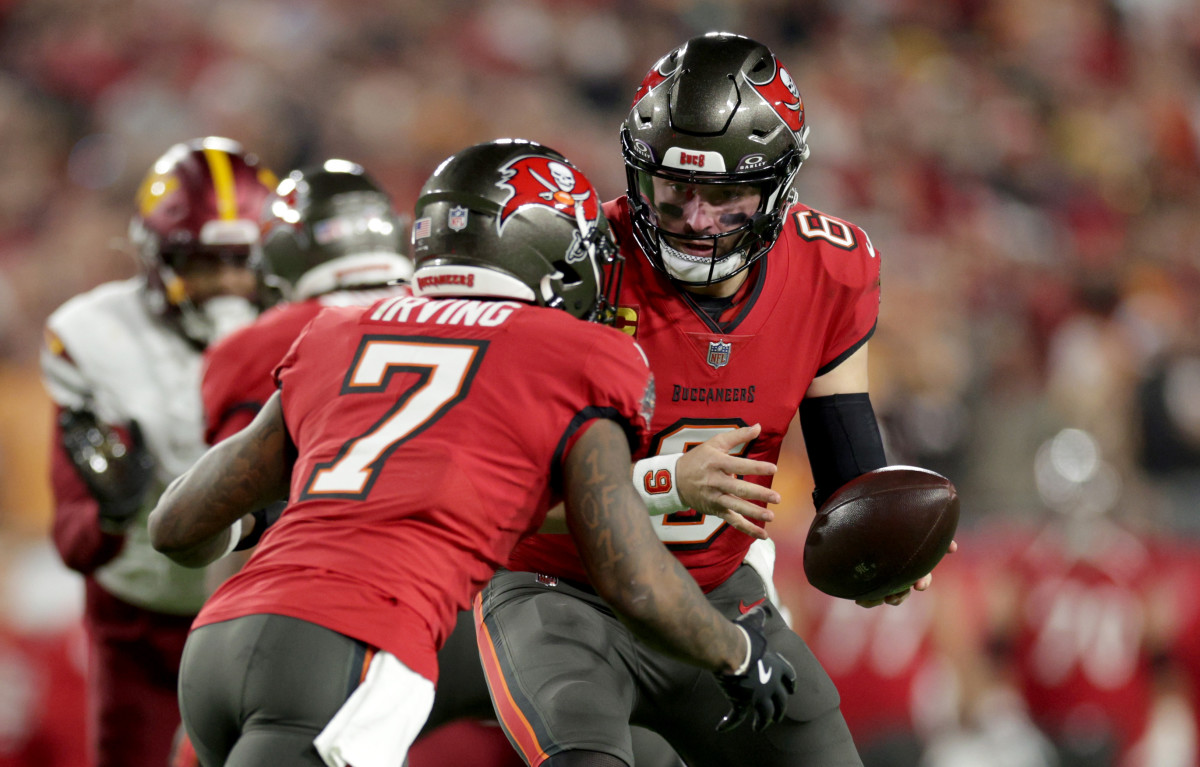 Jan 12, 2025; Tampa, Florida, USA; Tampa Bay Buccaneers quarterback Baker Mayfield (6) hands off to running back Bucky Irving (7) during the first quarter of an NFC Wild Card playoff against the Washington Commanders at Raymond James Stadium.