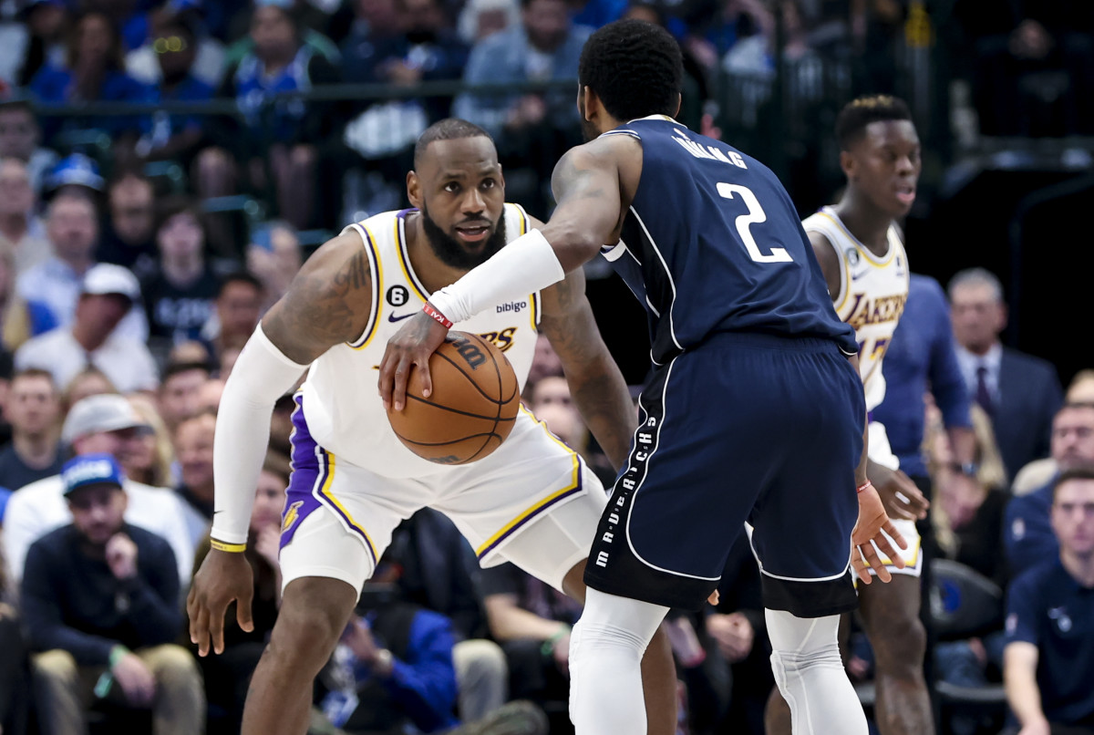 Los Angeles Lakers forward LeBron James defends Dallas Mavericks guard Kyrie Irving.