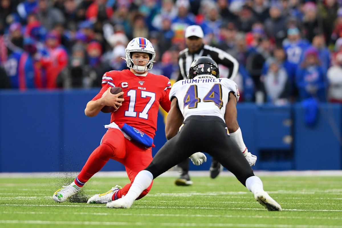 Buffalo Bills quarterback Josh Allen (17) slides after a run as Baltimore Ravens cornerback Marlon Humphrey (44) defends during the fourth quarter at New Era Field.