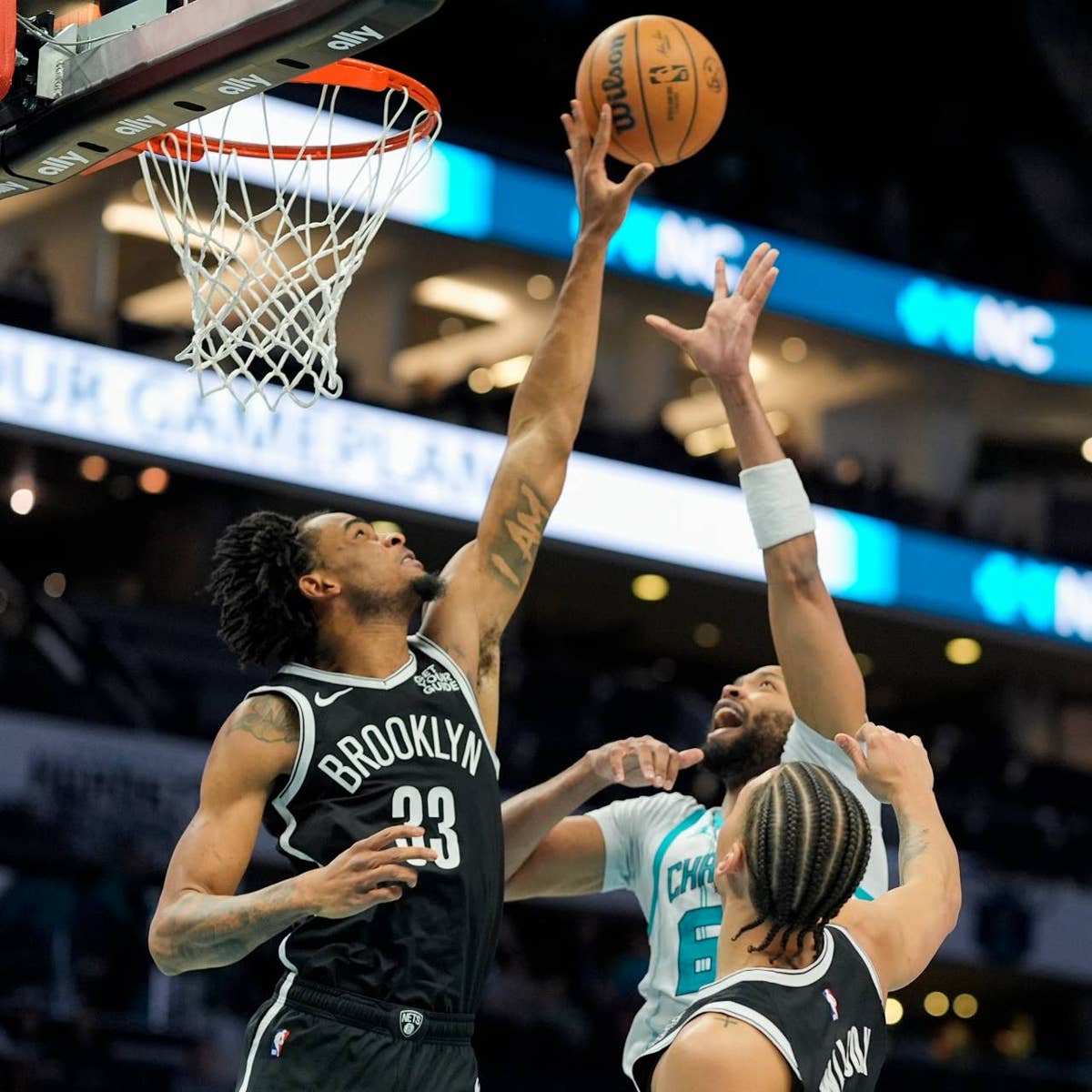 Nic Claxton blocks Taj Gibson of the Hornets.
