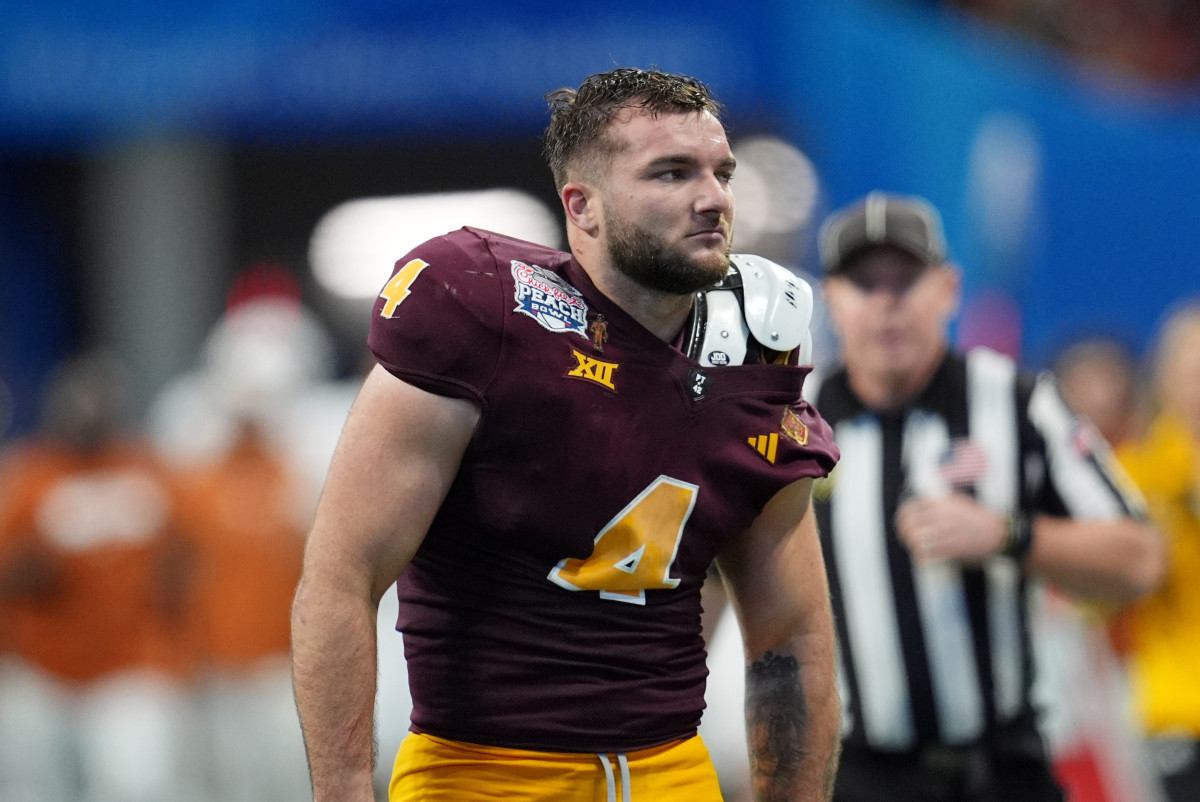 Jan 1, 2025; Atlanta, GA, USA; Arizona State Sun Devils running back Cam Skattebo (4) reacts after losing his helmet while being tackled by Texas Longhorns defensive back Michael Taaffe (16) during the second half of the Peach Bowl at Mercedes-Benz Stadium.