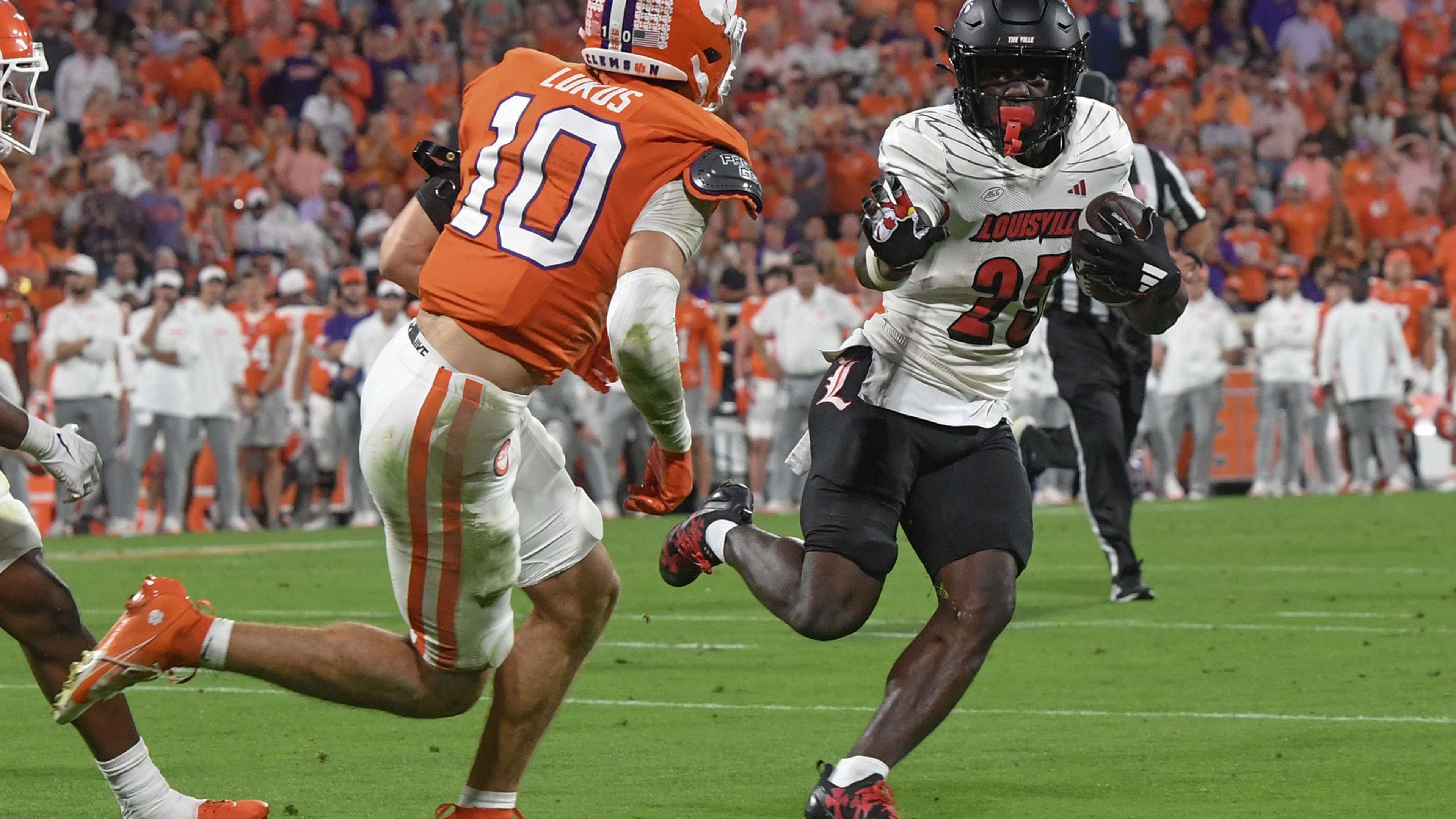 Louisville Cardinals running back Isaac Brown (25) runs the ball against Clemson Tigers cornerback Jeadyn Lukus (10).