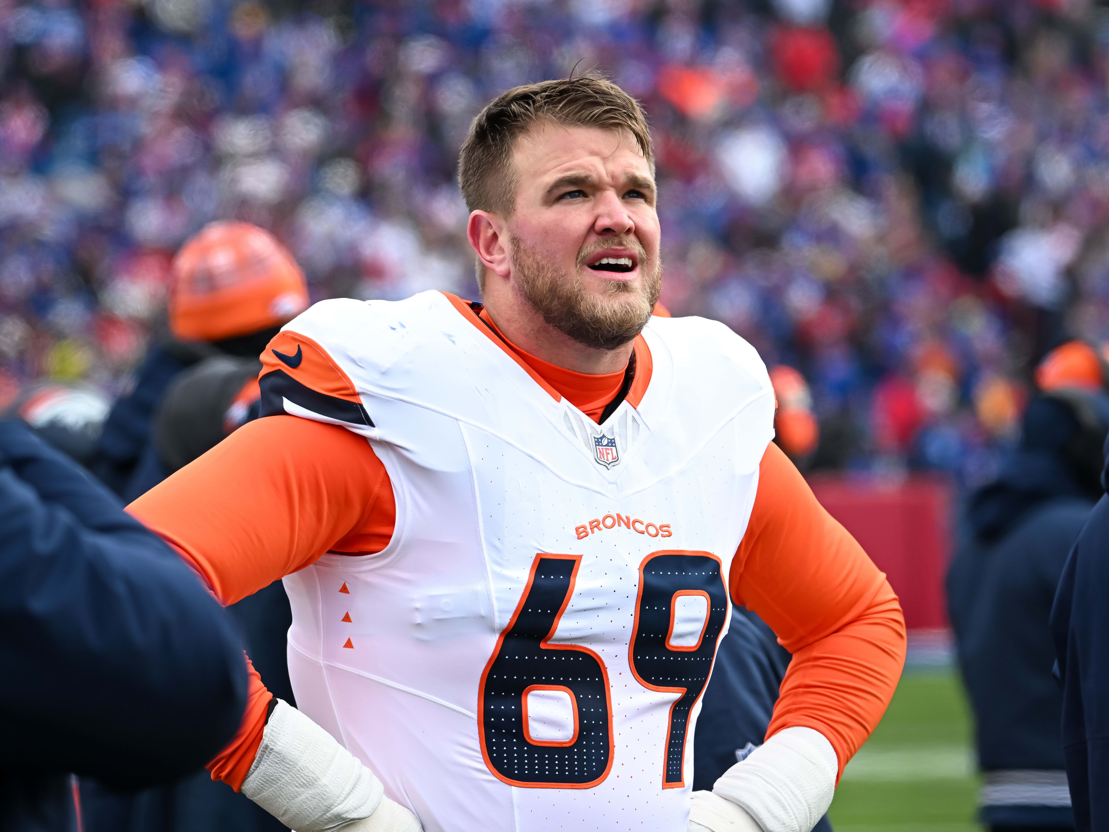 Jan 12, 2025; Orchard Park, New York, USA; Denver Broncos offensive tackle Mike McGlinchey (69) on the sidelines before an AFC wild card game against the Buffalo Bills at Highmark Stadium. Mandatory Credit: Mark Konezny-Imagn Images