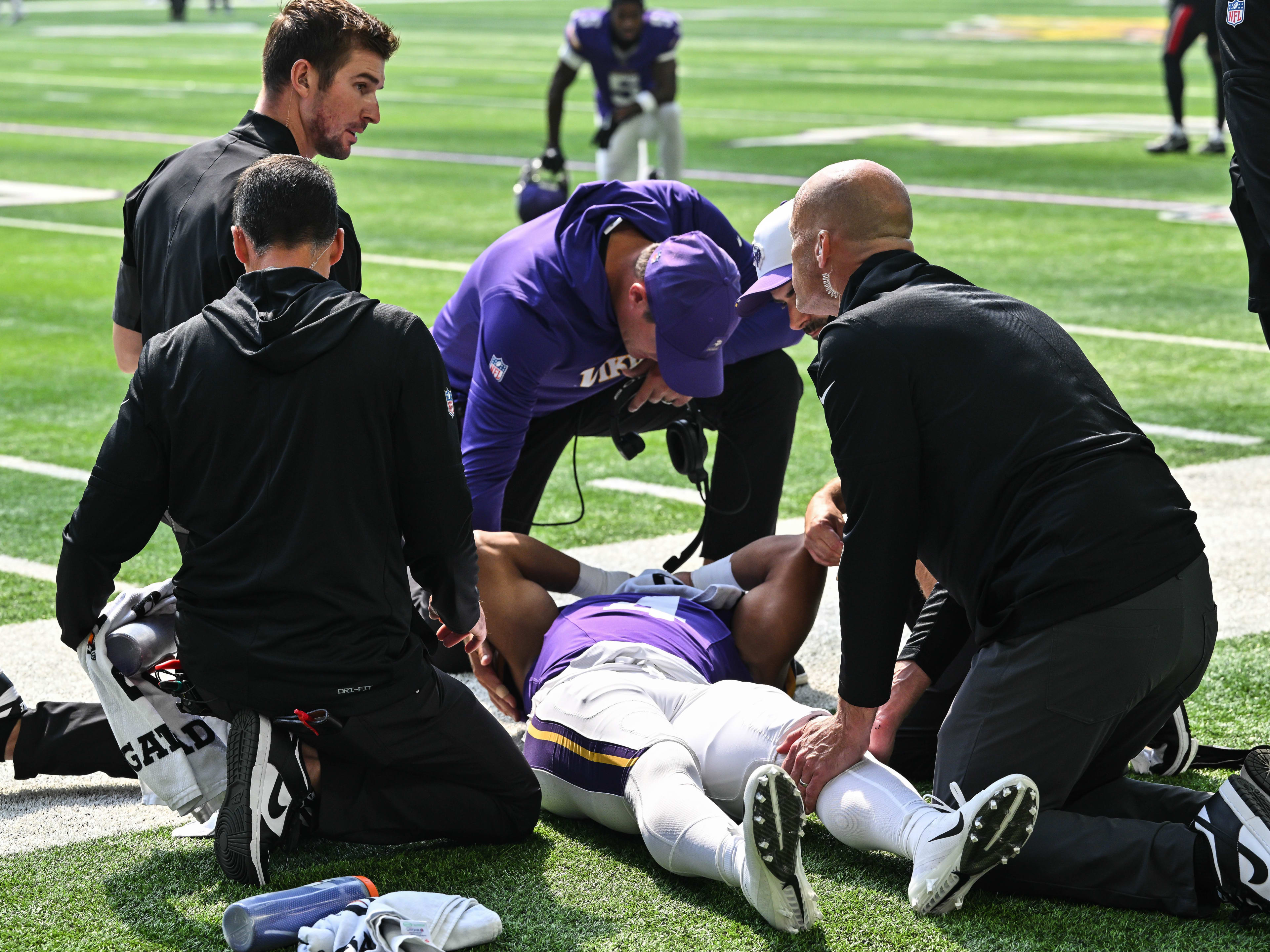 Aug 9, 2025; Minneapolis, Minnesota, USA; Minnesota Vikings wide receiver Rondale Moore (4) is attended to by head coach Kevin O’Connell and trainers after suffering a lower leg injury during the second quarter against the Houston Texans at U.S. Bank Stadium. Mandatory Credit: Jeffrey Becker-Imagn Images