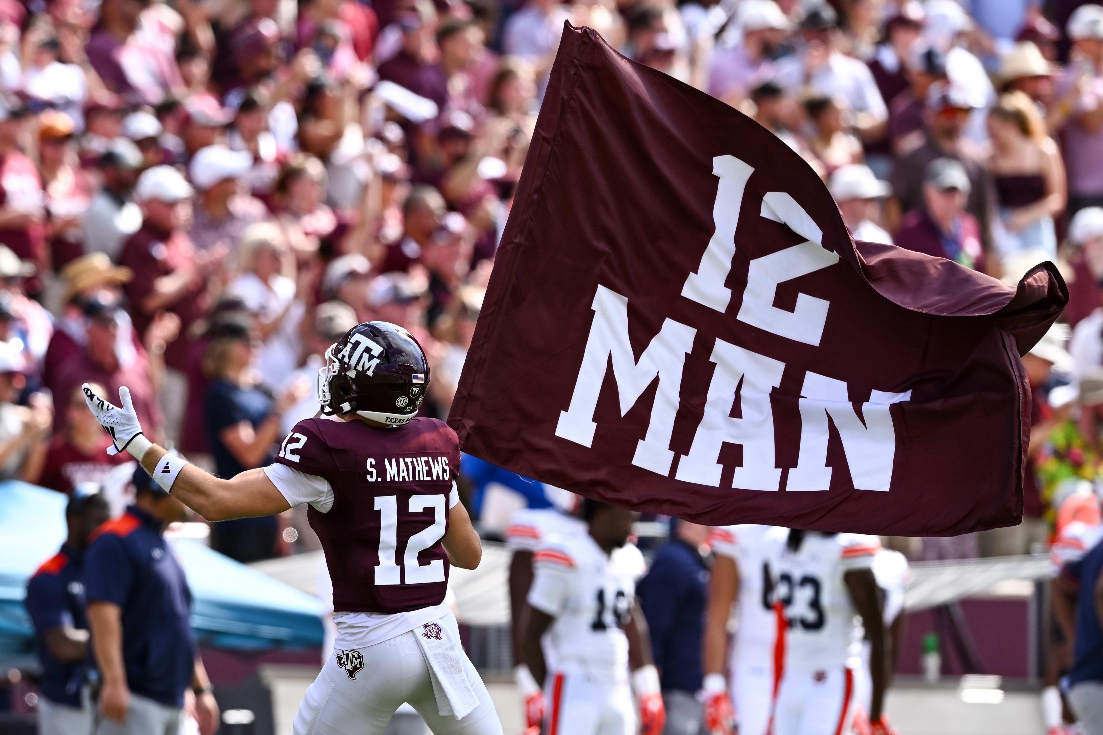 Sep 23, 2023; College Station, Texas, USA; Texas A&M Aggies linebacker Sam Mathews (12) waves the 12th Man flag during pre-game runout against the Auburn Tigers at Kyle Field.