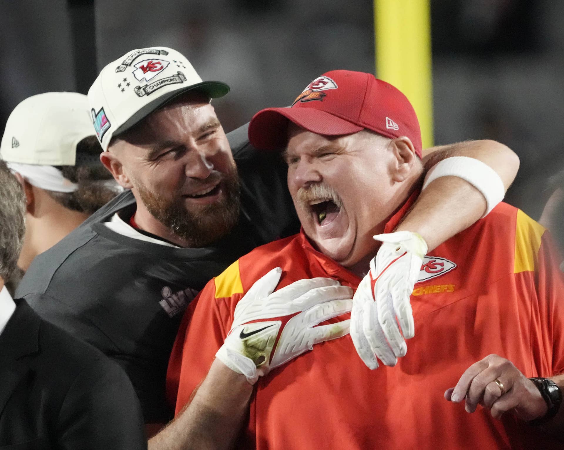 Chiefs coach Andy Reid celebrates on the podium with tight end Travis Kelce, left, after Kansas City defeated the Eagles in Super Bowl 57.