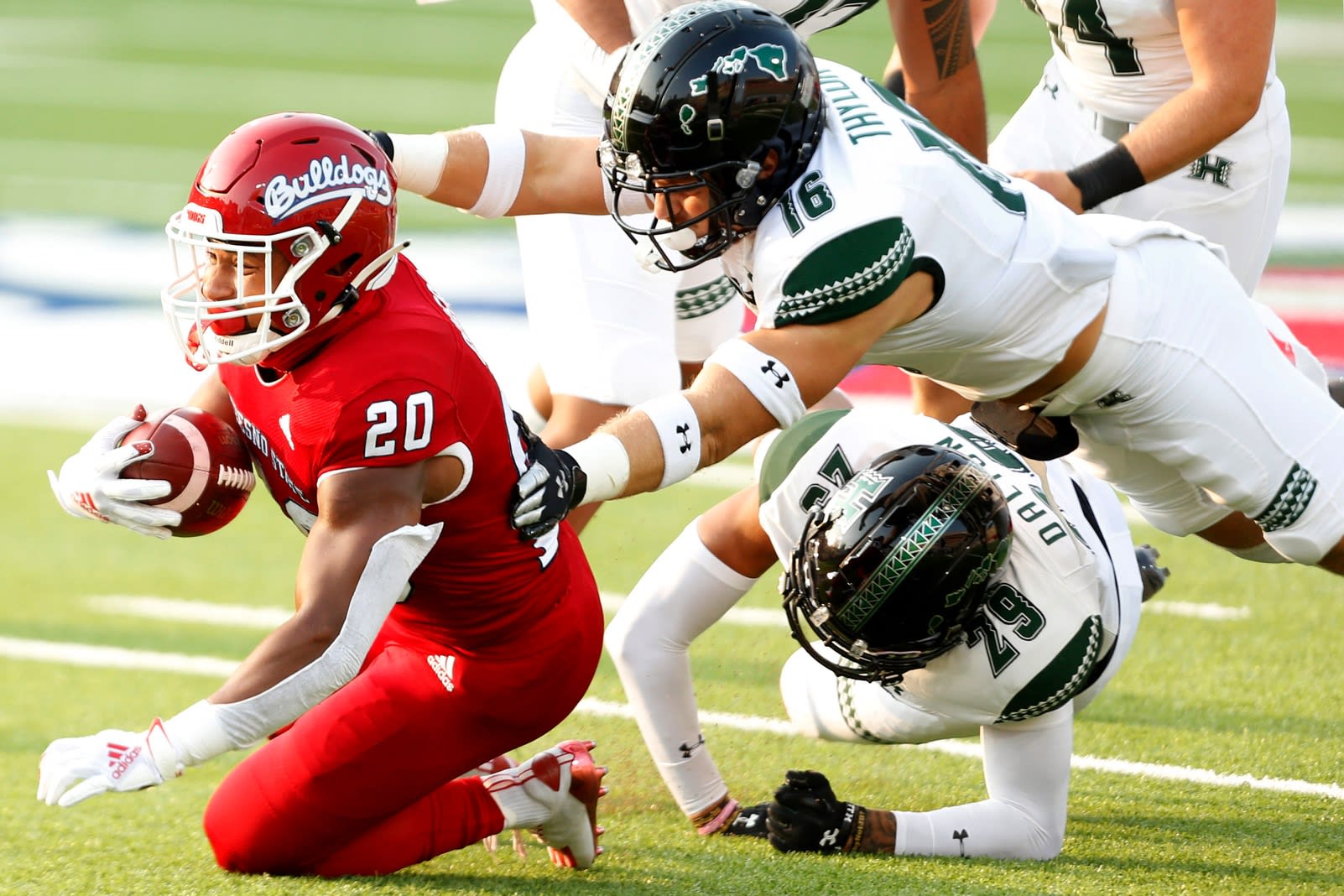 Fresno State Bulldogs running back Ronnie Rivers (20) is tackled by Hawaii Rainbow Warriors defensive back Logan Taylor