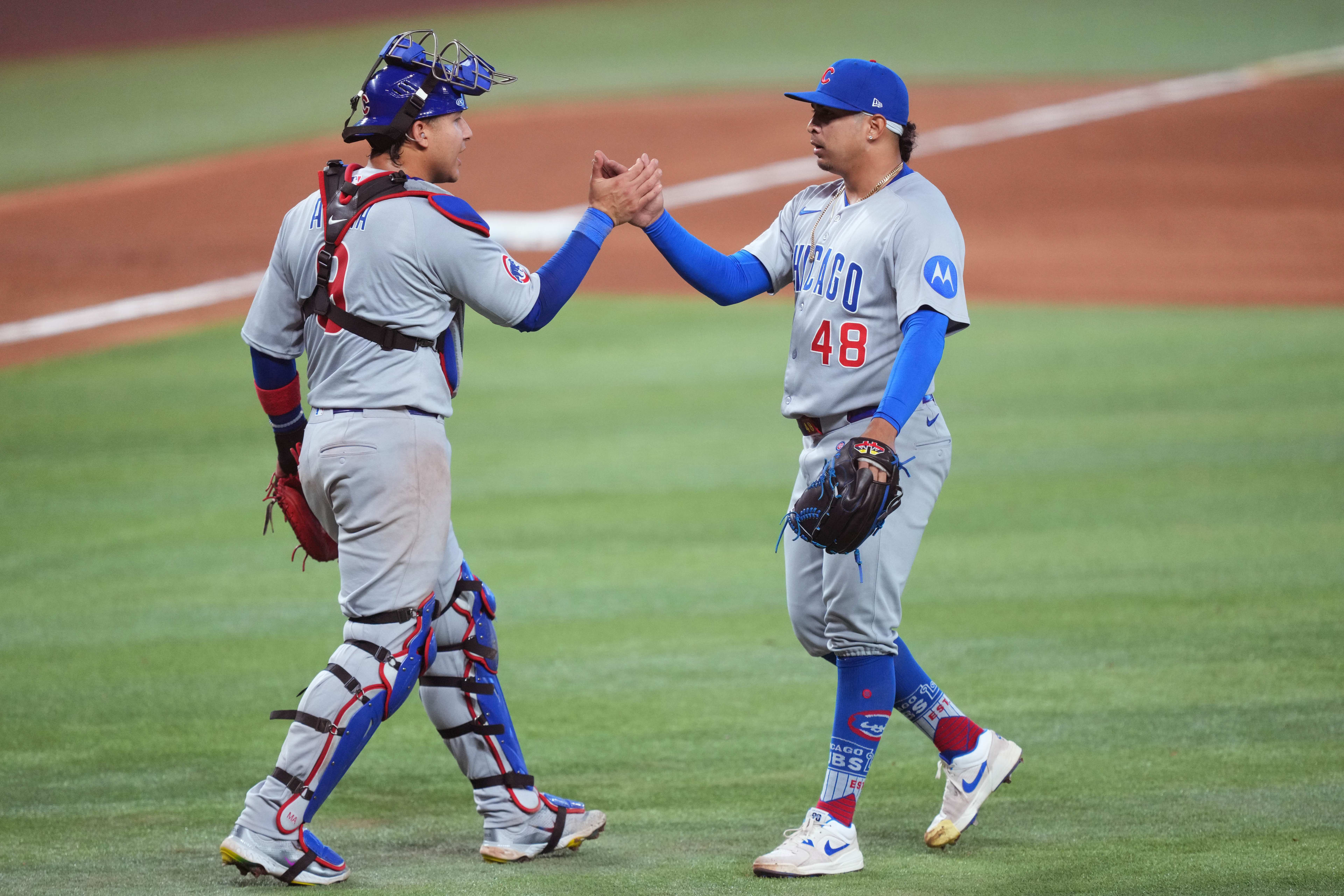 Chicago Cubs pitcher Daniel Palencia (48) and catcher Miguel Amaya (9) celebrate a victory against the Miami Marlins at loanDepot Park.