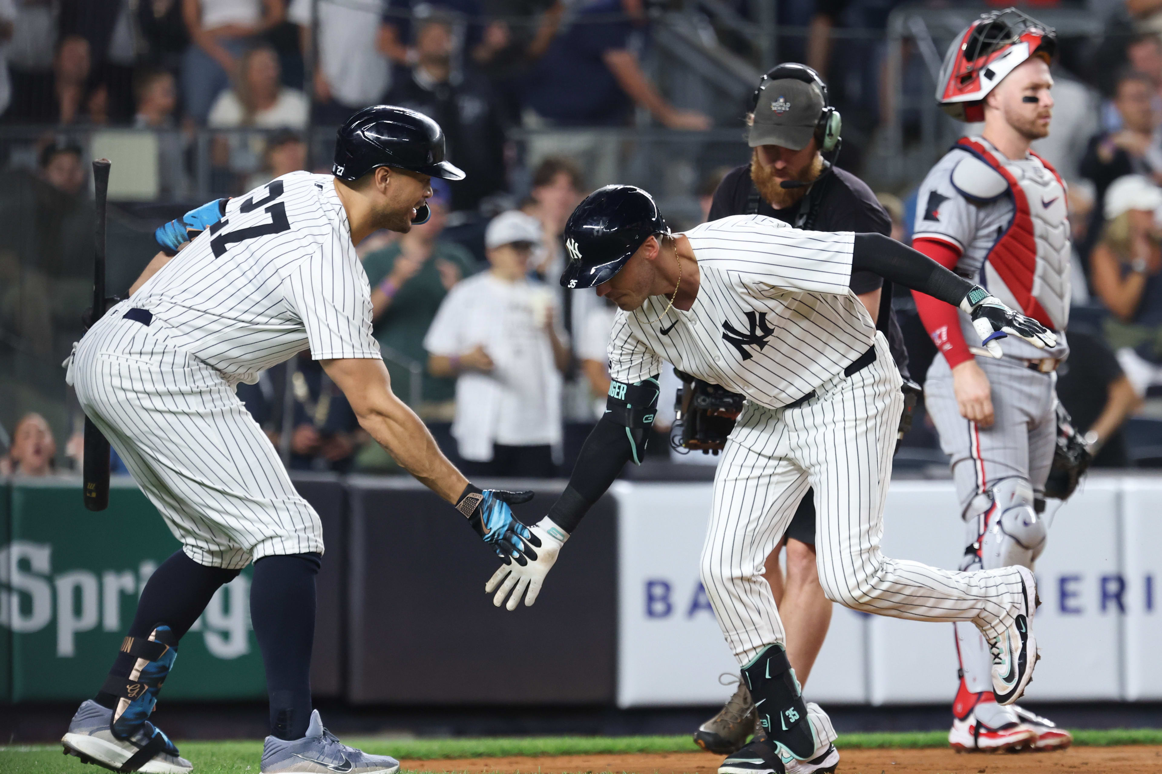 New York Yankees left fielder Cody Bellinger (35) celebrates with right fielder Giancarlo Stanton (27)