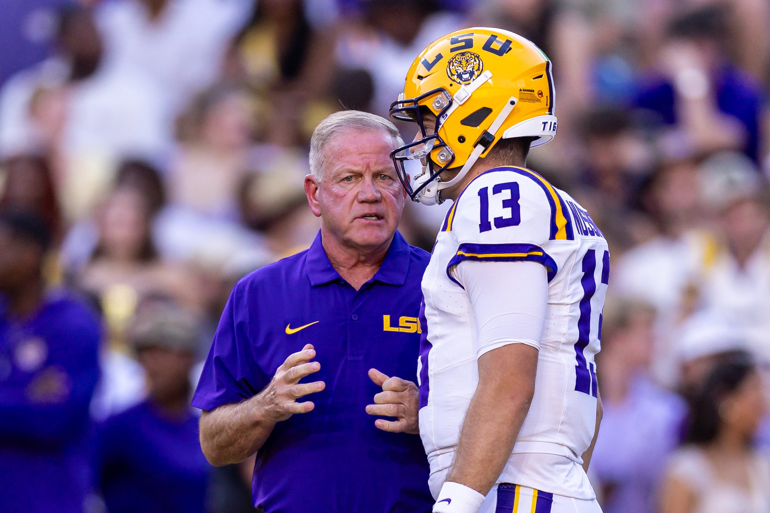 LSU Tigers quarterback Garrett Nussmeier (13) talks to head coach Brian Kelly.