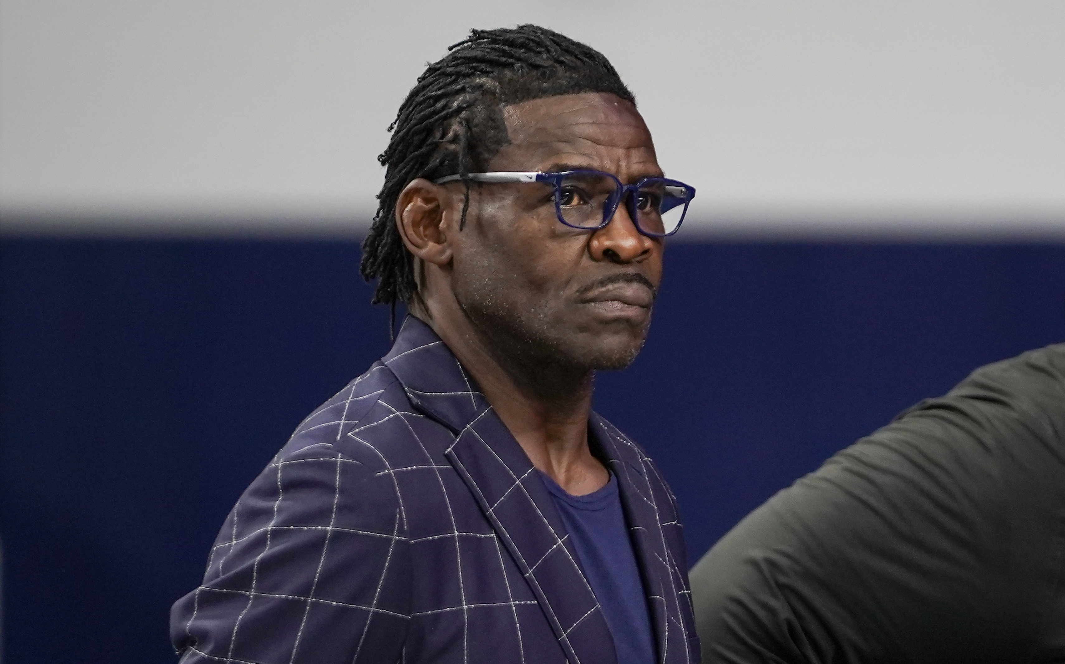 Former Dallas Cowboys wide receiver Michael Irvin looks on as Deion Sanders speaks with the media
