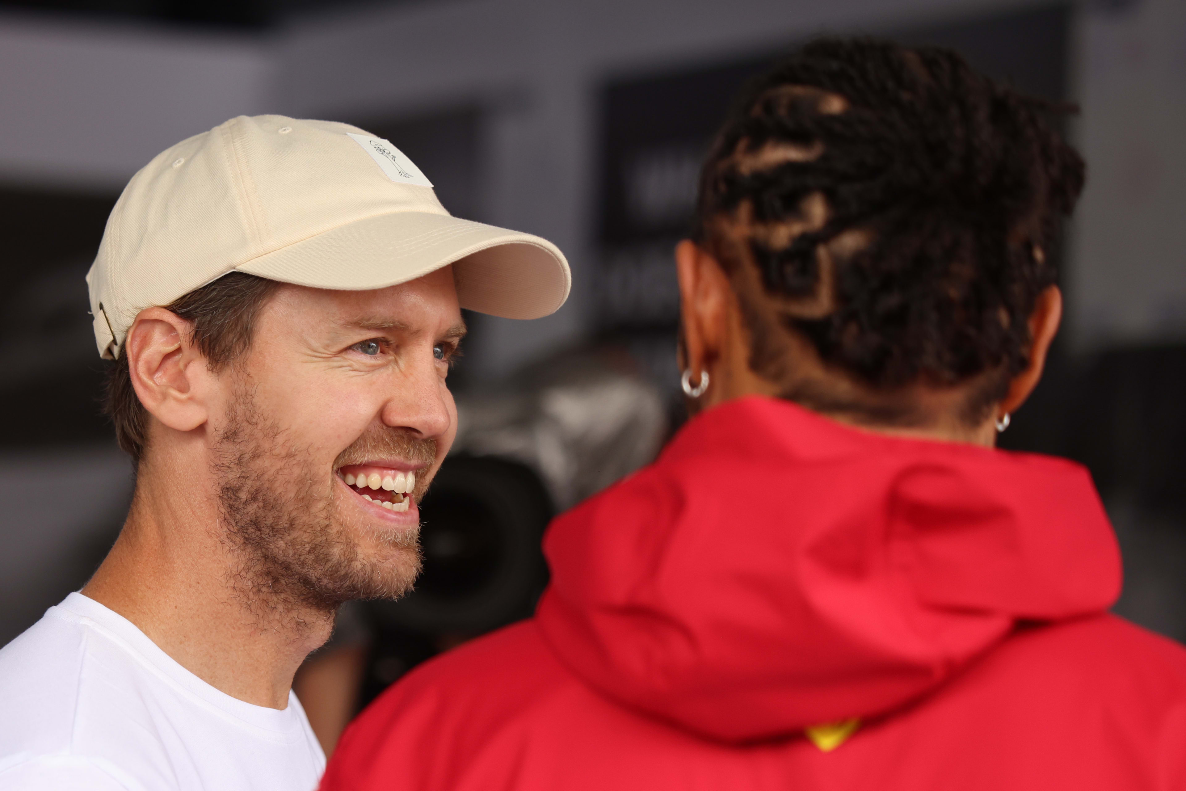 Sebastian Vettel and Lewis Hamilton of Great Britain and Scuderia Ferrari talk in the Forest F1 garage prior to the F1 Grand Prix of Brazil at Autodromo Jose Carlos Pace on November 09, 2025 in Sao Paulo, Brazil.