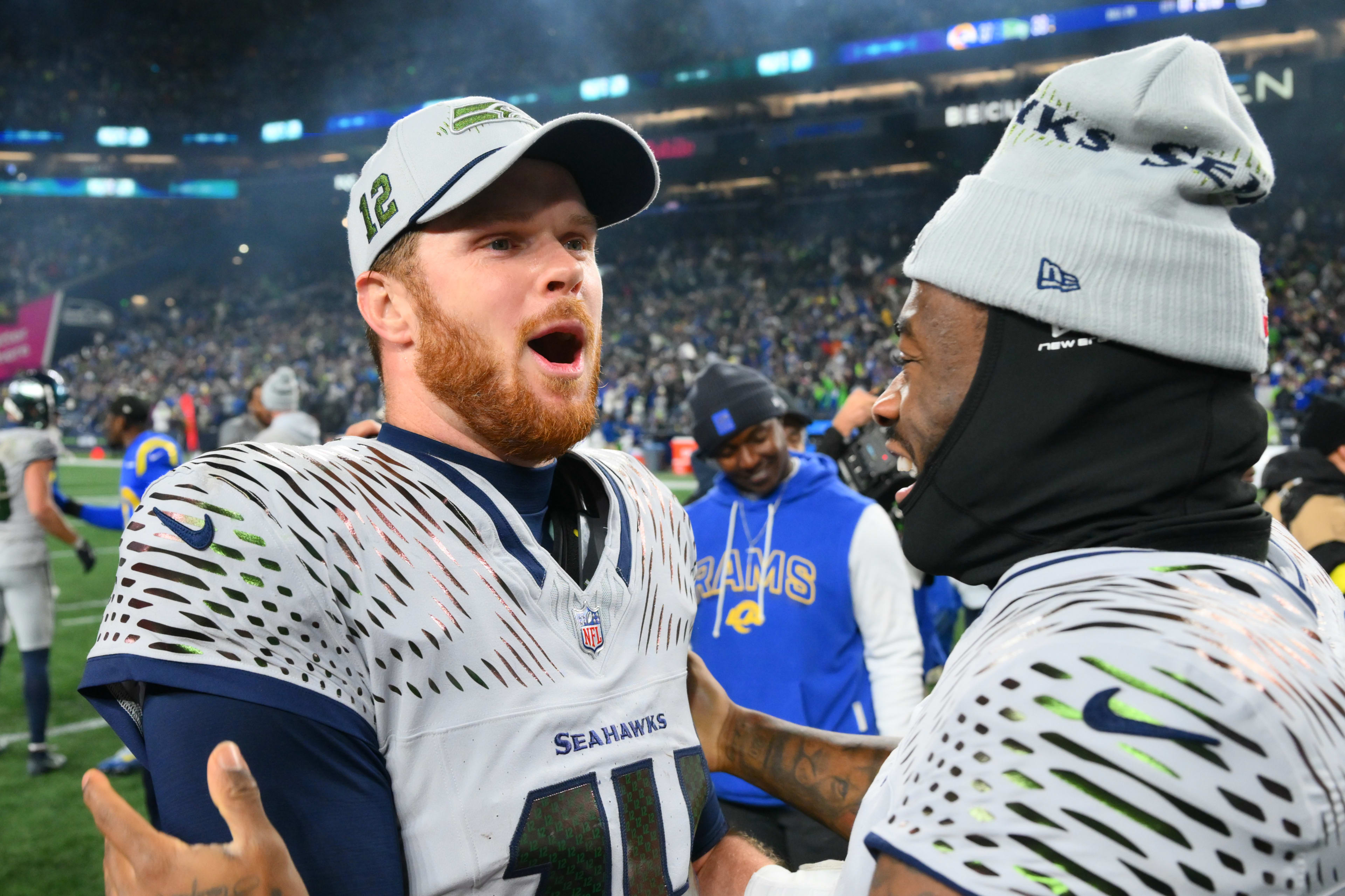 Seattle Seahawks quarterback Sam Darnold (14) and quarterback Jalen Milroe (6) celebrate after defeating the Los Angeles Rams in overtime at Lumen Field.